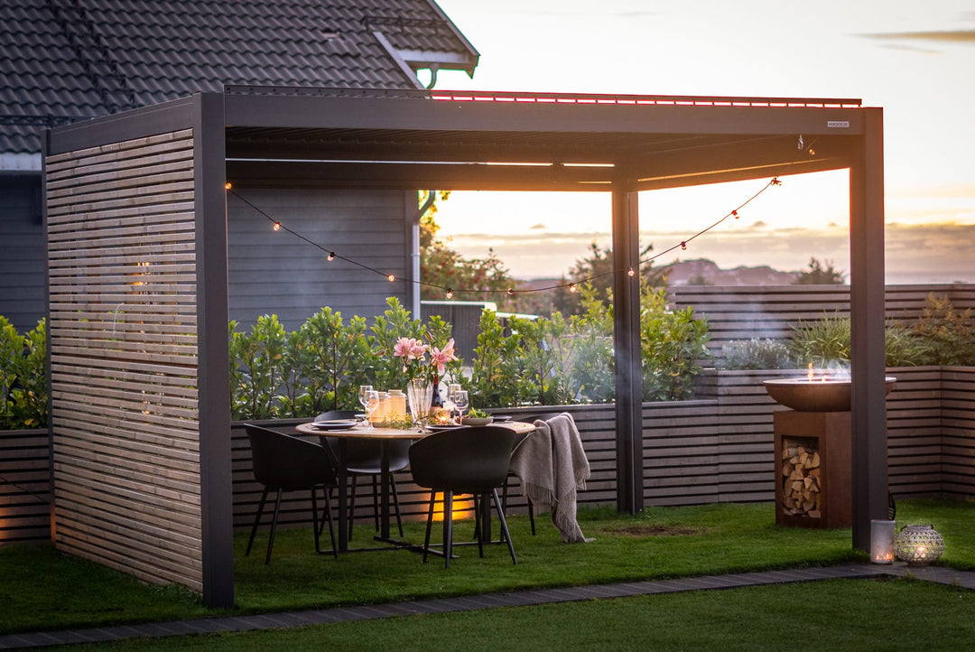 Área externa coberta com pérgola de lâminas, projetor de 100 polegadas e grupo de amigos assistindo futebol à noite